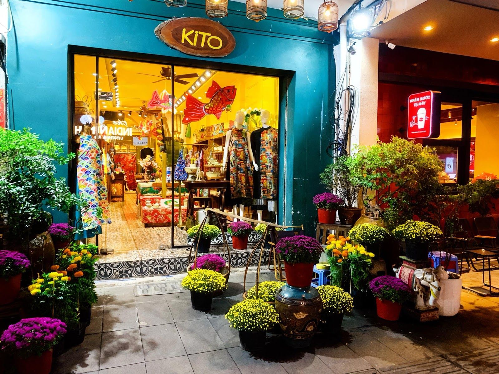 KiTO 店頭 — 黄色い壁と緑の窓枠、花に囲まれた入口